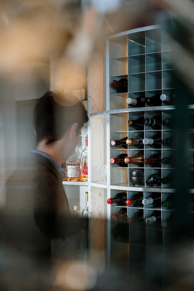 άνδρας μπροστά σε ράφι με κρασιά