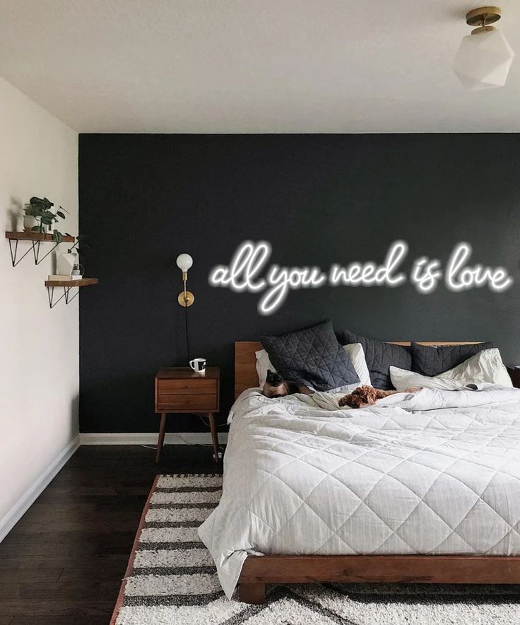 neon επιγραφή all you need in love πάνω από το κρεβάτι