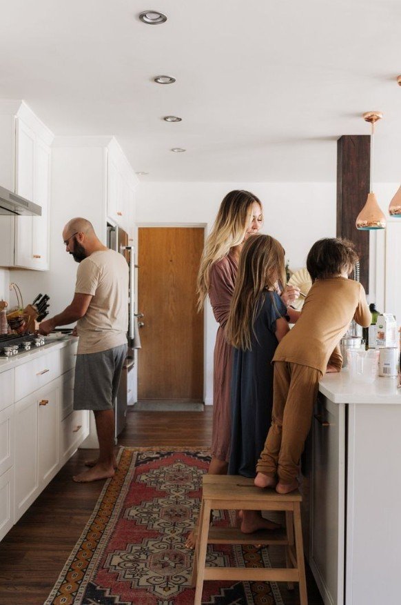 οικογένεια (μαμά, μπαμπάς, 2 παιδιά) να προετοιμάζουν πρωινό στην κουζίνα